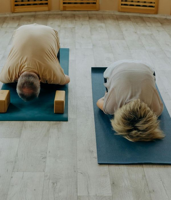 Person practicing a calm yoga pose in a bright room.